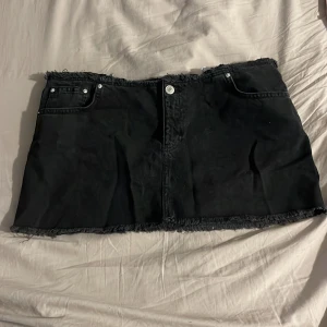 Svart jeanskjol från Pull&Bear - Svart kort jeanskjol från Pull&Bear med fransiga kanter. De är i jätte bra skick, jag har bara testat de. Jag köpte den för runt 300kr. Perfekt till sommaren. Priset kan diskuteras 