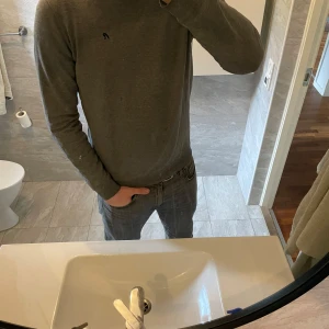 Grå långärmad tröja från Replay - Säljer en grå långärmad tröja från Replay med diskret svart broderad logga på bröstet. Tröjan har rund halsringning och är i mjukt material, perfekt för en enkel och clean look.