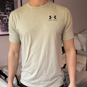 Beige t-shirt från Under Armour - Tränings-T-shirt från Under Armour i bomull.