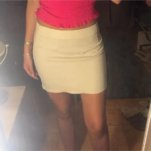 Beige kortkjol - Snygg beige kortkjol med en tight passform. Perfekt för sommarens alla tillfällen. Kjolen är stilren och enkel att matcha med olika toppar.