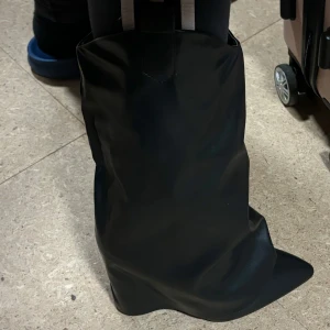 Svarta stövlar med spetsig tå - Snygga svarta stövlar i syntetmaterial med spetsig tå. Perfekta för en stilren look. De har en enkel design utan extra detaljer, vilket gör dem lätta att matcha med olika outfits.