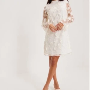 Vit studentklänning med blommor och spets - Superfin vit kortklänning med  transparenta ärmar och 3D-blommor i spets. Perfekt för sommarens speciella tillfällen eller student. Använd en gång och kemtvättad efteråt🌸🌸