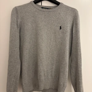 Ralph Lauren tröja - Säljer en stilren grå tröja från Polo Ralph Lauren med det klassiska broderade logotypen på bröstet. Perfekt för en avslappnad och snygg look. Bra skick. Pris kan diskuteras. Hör av er vid frågor. M men passar S också. 