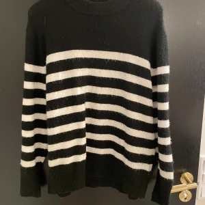 Svart och vit randig tröja från H&M - Säljer en svart och vit randig tröja från H&M. Tröjan har långa ärmar och är stickad för en mysig känsla. Perfekt för kyligare dagar med sin klassiska design.