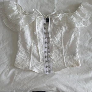 Vit spetskorsett med volang - Aldrig använd, fråga för bilder på hur den sitter!