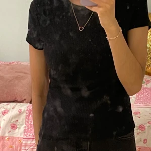 Svart ribbad t-shirt från H&M - Säljer en svart ribbad t-shirt från H&M Basic. T-shirten har korta ärmar och rund halsringning. Enkel och stilren modell som passar perfekt till jeans eller kjol.