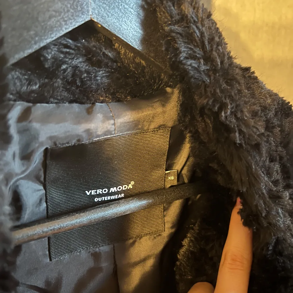 Säljer en svart, fluffig päls kappa från Vero Moda. Den har lång ärm och en mjuk, vågig struktur i materialet. Perfekt för dig som vill ha en trendig kappa med lite extra attityd.. Takit.