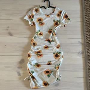 Vit klänning med solrosmönster från Shein - Säljer en söt vit klänning från Shein med solrosmönster. Passar som en XXS. Perfekt för sommarens varma dagar! 🌻