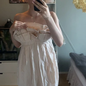 Ljus axelbandslös klänning H&M Garden - Superfin ljus axelbandslös kortklänning från H&M Garden Collection. Klänningen har voluminös överdel med veck och markerad midja. Mjuk, lätt bomullskänsla och dragkedja i sidan. Perfekt för sommarens alla tillfällen! Tanken var att jag skulle sy om den men de blev aldrig av men de är en så himla fin klänning. Skulle säga att den är mer som en M faktiskt 