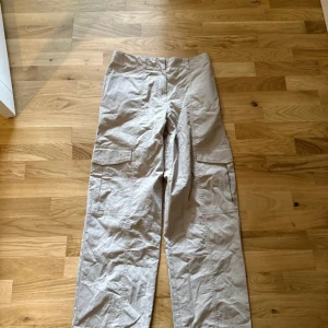 Beige cargobyxor med raka ben - Säljer ett par beige cargobyxor med raka ben och stora fickor på sidorna. Aldrig använt. 