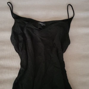 Svart linnetopp från Xoul Edition - Säljer en svart linnetopp från Xoul Edition i storlek S. Toppen har tunna axelband och en enkel, stilren design som är lätt att matcha. Perfekt för dig som gillar minimalistisk stil och vill ha något snyggt och bekvämt.