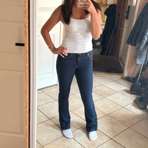 Mörkblå bootcut jeans - Säljer ett par mörkblå jeans med bootcut-modell och klassisk femficksdesign. Lite slitna i ena benet(se på sista bilden)🥰