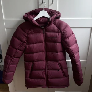 Vinröd dunjacka Peak Performance XS - Säljer min fina vinröda dunjacka från Peak Performance i storlek XS. Jackan är endast använd ett fåtal gånger. Den är ÄKTA och nypris var 3000 kr. Säljer pga den blev för liten. 