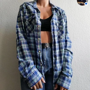 Blå rutig overshirt i bomull - Snygg blå rutig overshirt med knappar framtill och två bröstfickor. Skjortan har en loose passform och långa ärmar, perfekt att bära öppen över en t-shirt eller crop top. Tillverkad i mjuk bomull för en avslappnad vibe.