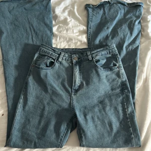 Bootcut jeans i ljusblå denim från Shein - Säljer ett par ljusblå bootcut jeans från Shein i storlek M. Jeansen har klassisk femficksdesign, hög midja och är tillverkade i en mjuk denimblandning med polyester. Snygg passform som sitter tajt upptill och släpper ut vid benslutet.