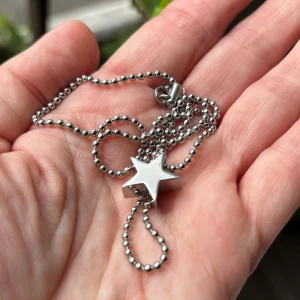 Stor stjärna, Edblad halsband - Stilrent halsband i stål/silverfärg från Edblad. Äldre modell som inte säljs längre. Lite tjockare kulkedja med fast lås. Stjärnan är ca 1,5 cm spets till spets och ca 0,5 cm tjock. Använt kanske en gång, sen bara legat i en låda. Perfekt för dig som gillar minimalistiska smycken, passar till allt ✨