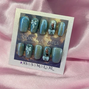 TaylorBlue (XS);Short Coffin  - Handgjorda press-on naglar i skimrande blått med cateye effekt. Dekorerade med 3D-ljusblå rosetter och bild av Taylor Swift. Naglarna har en coffin form och kommer i XS: 14 mm, 11 mm, 11,5 mm, 10 mm, 8 mm. Perfekt för dig som vill ha en unik och söt look.