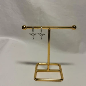 Silvriga örhängen med nyckelberlocker - Unika silvriga örhängen med små nyckelberlocker som har vingar. Ringarna är dekorerade med glittriga stenar för extra bling. Perfekt för dig som gillar detaljer och vill sticka ut med coola accessoarer.