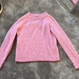 Ljusrosa stickad tröja Vero Moda XS - Superfin ljusrosa stickad tröja från Vero Moda i storlek XS. Tröjan har rund halsringning, ribbade muddar och är långärmad. Perfekt för dig som gillar en enkel men söt look med mjuk känsla.