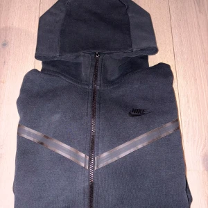 Svart Nike tech fleece - Svart tech fleece hoodie från Nike med hel dragkedja och huva.