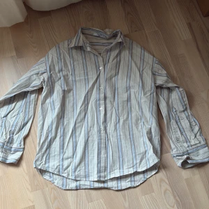 Oversized randig skjorta - Oversized randig skjorta från NAKD i beiga och blå toner! Använd två gånger!