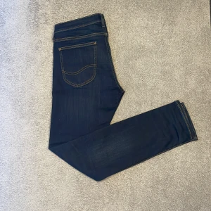 Mörkblå slimfit jeans från lee - Säljer ett par mörkblå Lee jeans modell (luke) i utmärkt skick som har en snygg slim look till sig. Jeans fungerar perfekt för vardaglig klädsel men kan kläs upp till en utmärkt festlook🍾                                         •skicka ett dm om eventuell frågor🙋              •Pris kan diskuteras vid snabb och smidig affär💸