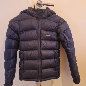 Peak Performance frost down jacket - Snygg mörkblå dunjacka från Peak Performance, är i jättebra skick. Har en liten defekt som man kan se på sista bilden, men det syns inte. Pris kan diskuteras.