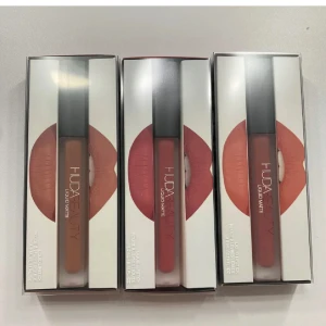 Huda Beauty Liquid Matte läppstift 2-pack - Säljer två Huda Beauty Liquid Matte läppstift i färgerna Trendsetter (varm brun) och Bombshell (mjuk nude-rosa). Oöpnade och oanvända i originalförpackning. Perfekt för dig som älskar matta, pigmentrika läppar. OBS: Färgen ICON är såld. Man kan se swatch på färgerna i andra bilden. Priset är per styck