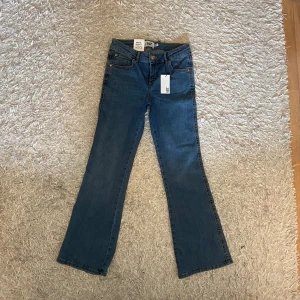 Bootcut jeans - Blå bootcut jeans från Lager 157 i modellen 90's Boot Star, helt nya. Klassisk femficksdesign med snygga bakfickor med lock och kopparfärgade knappar. Byxorna är mid waisted. Dom är i storlek 160, sitter som S/XS. Skriv gärna om du har frågor och läs helst min bio innan du köper💕 Kan diskutera priset!
