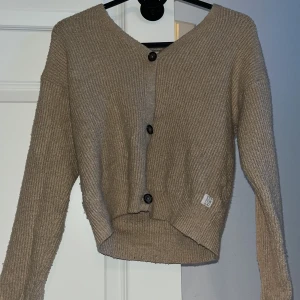 Beige kofta från Lager 157 - Säljer en beige kofta från Lager 157 med tre svarta knappar framtill. 