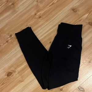 Mörkblå tights från Gymshark - Säljer ett par mörkblå leggings från Gymshark med hög midja och stretchigt material. De har mycket buttscrunch,mm. Ser svarta ut på bilden men är mörk blåa