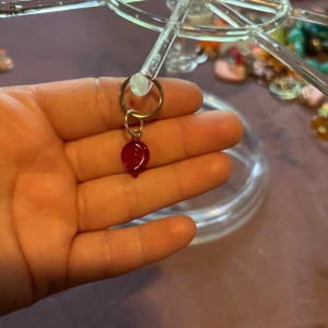  nyckelring   - En nyckelring med ett litet rött löv som hänger från en silverfärgad ring. Perfekt för dig som vill sticka ut med en färgklick.