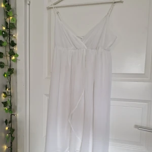 Vit långklänning Soaked in Luxury - Superfin vit långklänning från Soaked in Luxury med tunna axelband och v-ringning. Klänningen har ett luftigt fall och är perfekt för varma dagar. Materialet känns lätt och svalt mot huden. Köpt för ca 800 kr men säljer för 300kr🩷💞 Inga defekter och är i princip ny.