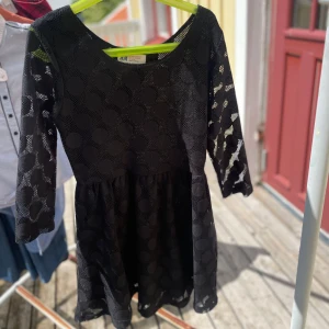 Svart prickig klänning från H&M - Svart kortklänning från H&M med stora prickar i mesh-tyg. Klänningen har trekvartsärm och rund halsringning. Den är figursydd upptill och har en lätt utställd kjol. Perfekt för dig som gillar en cool och lekfull stil. ( priset går att diskutera vid snabbt köp )