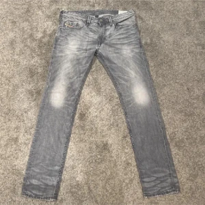 Grå Diesel jeans - Snygga grå jeans från Diesel med slitna detaljer och tvättad look. Modellen är slim fit. Mycket bra skick och storlek 32:32. Hör gärna av vid fler funderingar!