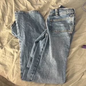 Ljusblå jeans från 157, storlek XS - Säljer ett par klassiska ljusblå jeans från 157 i storlek XS. Jeansen är bootcut och låg midja och snygga framfickor med dubbla knappar i midjan. Perfekta för dig som gillar en enkel och tidlös denimlook.
