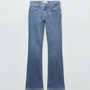 Blå bootcut jeans från Zara - Snygga blå bootcut jeans från Zara i klassisk denim. Modellen är figurnära upptill och utsvängda nertill för en trendig siluett⭐️ storlek xs, de är avklippta där nere eftersom de var alldeles för långa för mig när jag köpte☺️ jag är runt 162 för referens. Mycket bra skick annars 