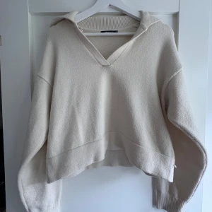 Beige stickad tröja  - Supermjuk beige trlja från Gina Tricot med v-ringad hals. Perfekt för lager på lager. Materialet är stickat och ger en chill och avslappnad vibe. Passar dig som gillar minimalistisk stil och neutrala färger.