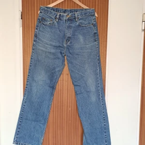 Blå raka jeans från Costillo - Klassiska blå jeans från Costillo med rak passform och normal midja. Jeansen har fem fickor, snygga kontrastsömmar och en cool läderpatch bak i midjan. Tillverkade i slitstarkt denim och perfekta för en avslappnad streetstil.