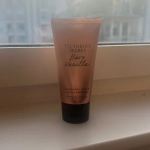 Victoria's Secret Bare Vanilla lotion - En lyxig doftlotion från Victoria's Secret i färgen roséguld med svarta detaljer. Tuben innehåller 75 ml och doftar vanilj och kashmir. Perfekt för dig som vill ha en söt och mjuk doft på huden. Smidig att ta med i väskan.