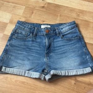 Jeans shorts  - Mörk blå jeans shorts från Lindex i storlek 146, från 10-11 år. En liten fläck, har endast försökt få bort den med vatten. Tror nog den går bort i tvättmaskin. 