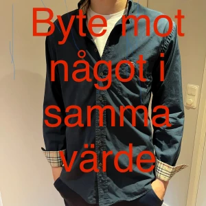 Mörkblå Burberry skjorta S - Snygg mörkblå skjorta från Burberry i bomull. Klassisk passform med långa ärmar, knappar framtill och ikoniskt rutigt tyg på insidan av kragen och manschetterna. Perfekt för dig som gillar stilrena plagg med exklusiv känsla. Tar gärna byten i samma värde!!!!