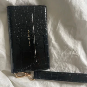 Ideal of sweden mobilhållare och plånbok - svart plånbok och mobilhållare från iDeal of Sweden för iphone 12. Aldrig använd.