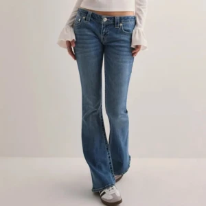 Blå bootcut jeans - Snygga blå långidjade bootcut jeans från True Religion med  broderade bakfickor. Endast andvända 1 gång och säljer pågrund av att det inte kommer till amdvändning😊💕