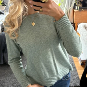 Grön stickad tröja - Säljer en mysig grön stickad tröja med långa ärmar och ribbade muddar. 