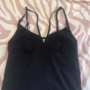 Svart topp från BikBok - Snygg svart topp  från BikBok med smala axelband och en stilren design. 
