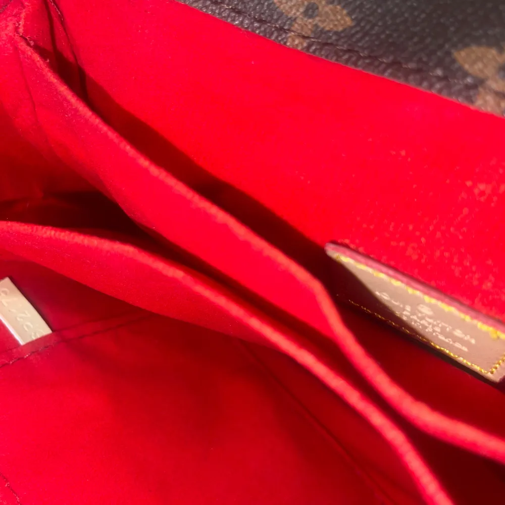 Säljer en elegant brun axelväska från Louis Vuitton med det ikoniska monogrammönstret. Väskan har en säker låsdetalj i guld och en praktisk dragkedja på insidan. Den röda insidan ger en lyxig känsla. Perfekt för att bära dina nödvändigheter med stil.. Laukut & Käsilaukut.