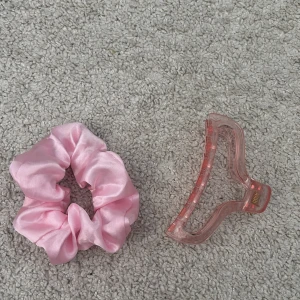 Rosa siden scrunchie och hårklämma - Säljer en söt rosa scrunchie i siden och en matchande rosa hårklämma. Perfekt för att snabbt fixa håret med stil. Scrunchien är mjuk och skonsam mot håret medan klämman ger ett bra grepp.