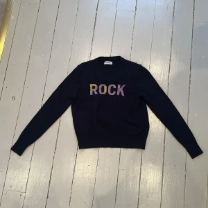 Marin blå  tröja med texten ROCK från ZADIG & VOLTAIRE ✨ - Säljer en marin blå  tröja med färgglad texten 'ROCK' på framsidan från ZADIG & VOLTAIRE. Tröjan har långa ärmar och en rund halsringning. Perfekt för en avslappnad stil. Om man gillar stockholm stil eller lite cool stil är detta en tröja för en .⚡️⚡️⚡️