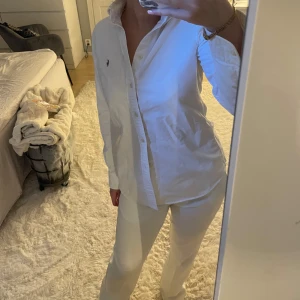 Vit skjorta från Ralph Lauren - Säljer en klassisk vit skjorta från Ralph Lauren i storlek S. Skjortan har långa ärmar och är tillverkad i bomull. Den har en broderad logotyp på bröstet och knappar framtill. Perfekt för en stilren look. Perfekt till lite finare tillställningar! Köpt andrahand men aldrig använd personligen. Tryck gärna på köp nu!💓😚